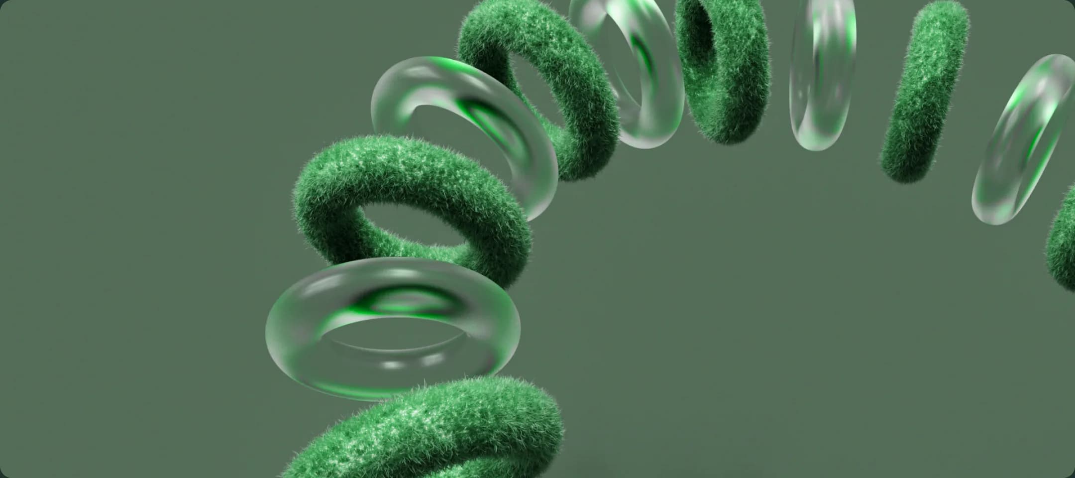 Rings of green-textured and clear glass arcing through a soft green space